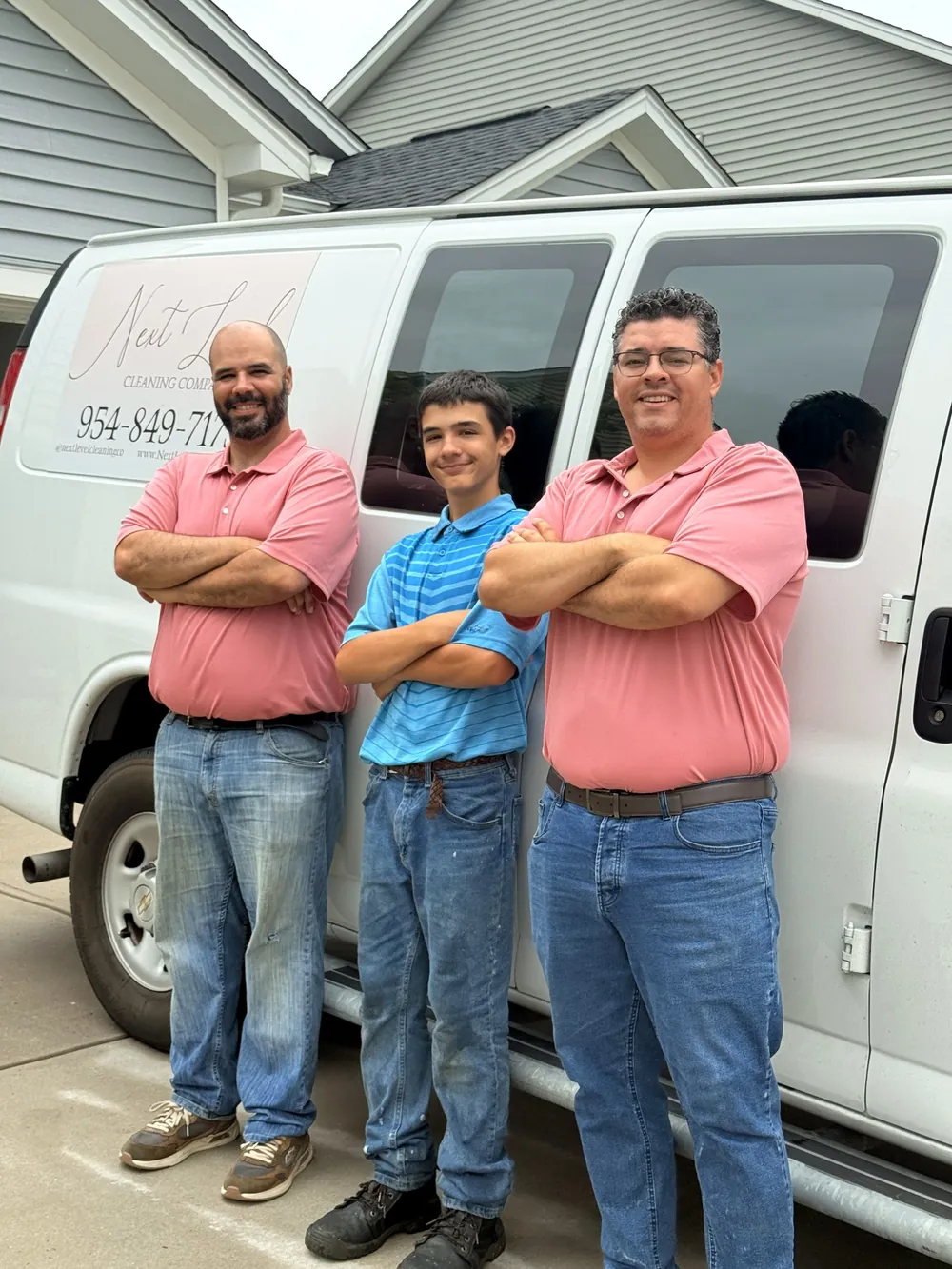 Next Level Cleaning team members beside the company van